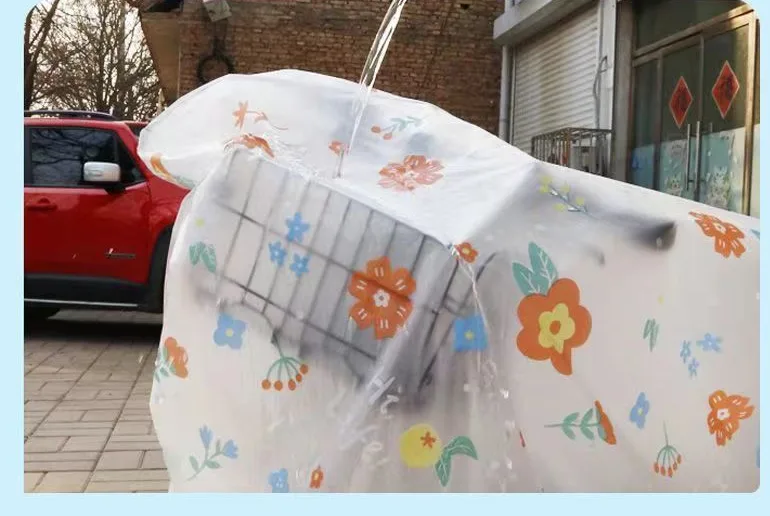 Water poured over a parked-bike cover beads up and runs straight off the printed PVC instead of soaking in